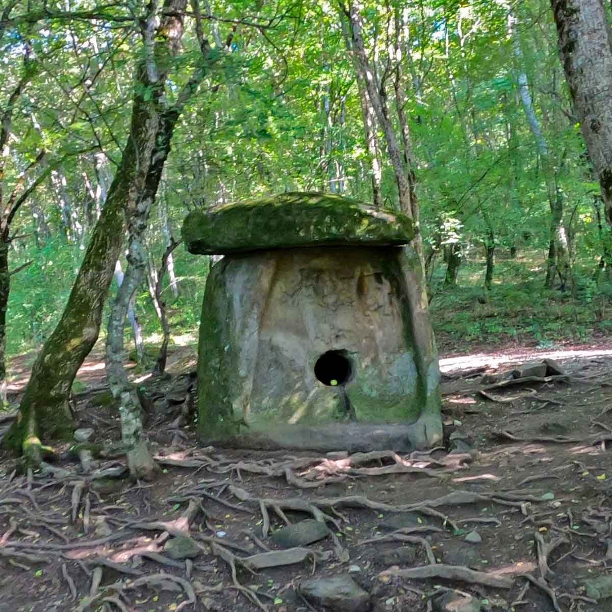 Дольмен Сердце матери фронтальный вид среди деревьев