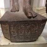 Каменное основание древнеегипетской статуи с глубокими иероглифами в старом Каирском музее