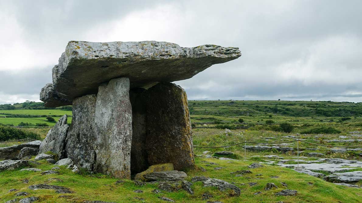 Камера дольмена Пульнаброн видна среди известняковых плит и низкой травы на плато
