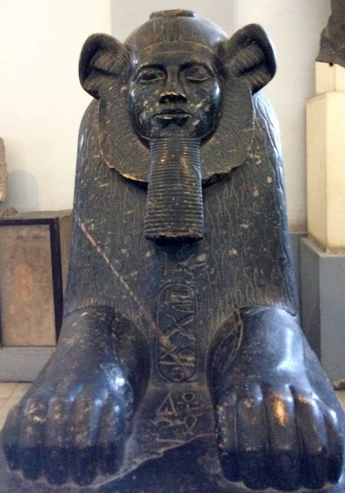 Небольшой тёмный сфинкс с человеческой головой в экспозиции каирского египетского музея
