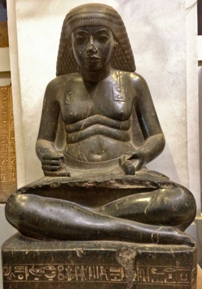 Сидящая женская каменная статуя с иероглифами в экспозиции каирского египетского музея